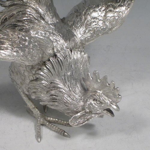 A very handsome Sterling Silver large pair of cast fighting cock cockerels or roosters, showing two male birds in realistic fighting poses, finely detailed with hand-chased bodies and tail feathers. This fantastic pair of silver fighting cocks were made by Francis Higgins of London in 1936. The dimensions of these fine hand-made sterling silver fighting roosters or cockerel cocks are length 30.5 cms (12 inches), height 27 cms (10.75 inches), and they weigh a total of approx. 1,240g (40 troy ounces).