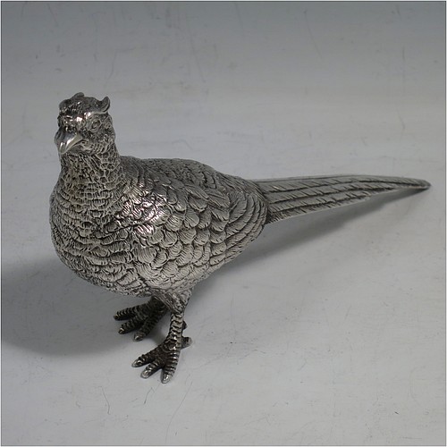 A cast Sterling Silver pair of pheasants, showing a male and female bird in realistic traditional poses, finely detailed with hand-chased bodies and tail feathers. Made by Robert Glover of London in 1973. The dimensions of these fine hand-made sterling silver pheasants are length of male bird 17 cms (6.75 inches), height 8 cms (3 inches), and they weigh a total approx. 310g (10 troy ounces).    