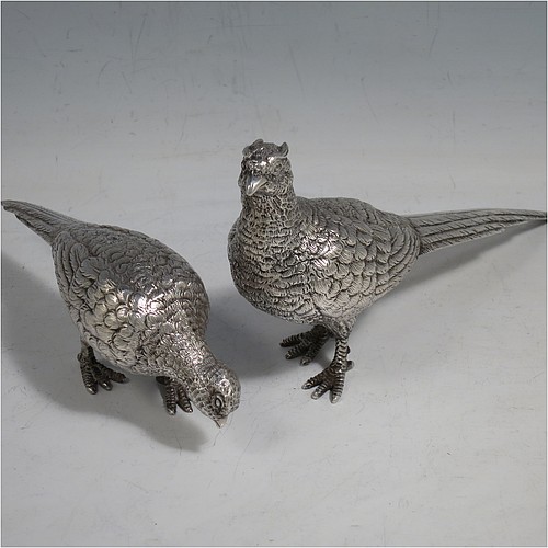 A cast Sterling Silver pair of pheasants, showing a male and female bird in realistic traditional poses, finely detailed with hand-chased bodies and tail feathers. Made by Robert Glover of London in 1973. The dimensions of these fine hand-made sterling silver pheasants are length of male bird 17 cms (6.75 inches), height 8 cms (3 inches), and they weigh a total approx. 310g (10 troy ounces).    