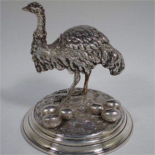 A very unusual Antique Victorian Silver-Plated inkstand and model of an Ostrich, having realistically hand-chased feathers, a hinged lid with an internal blue-glass liner inkwell, and standing on a cast round rock base with six ostrich eggs. Made in ca. 1880. The dimensions of this fine hand-made antique silver plated ostrich model and inkstand are height 15 cms (6 inches), and diameter of base 13 cms (5 inches).    