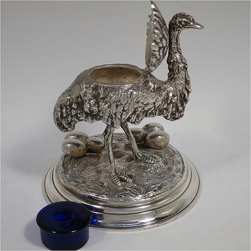 A very unusual Antique Victorian Silver-Plated inkstand and model of an Ostrich, having realistically hand-chased feathers, a hinged lid with an internal blue-glass liner inkwell, and standing on a cast round rock base with six ostrich eggs. Made in ca. 1880. The dimensions of this fine hand-made antique silver plated ostrich model and inkstand are height 15 cms (6 inches), and diameter of base 13 cms (5 inches).    