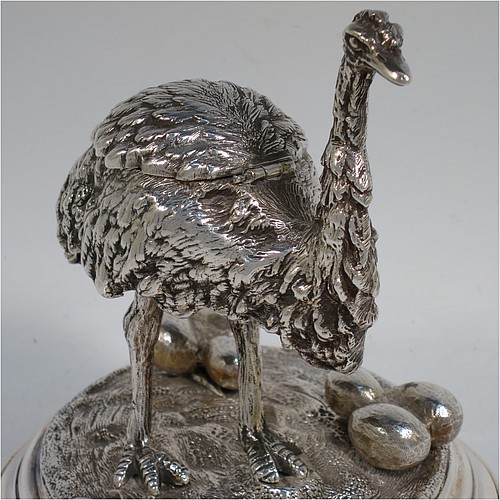 A very unusual Antique Victorian Silver-Plated inkstand and model of an Ostrich, having realistically hand-chased feathers, a hinged lid with an internal blue-glass liner inkwell, and standing on a cast round rock base with six ostrich eggs. Made in ca. 1880. The dimensions of this fine hand-made antique silver plated ostrich model and inkstand are height 15 cms (6 inches), and diameter of base 13 cms (5 inches).    