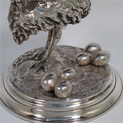 A very unusual Antique Victorian Silver-Plated inkstand and model of an Ostrich, having realistically hand-chased feathers, a hinged lid with an internal blue-glass liner inkwell, and standing on a cast round rock base with six ostrich eggs. Made in ca. 1880. The dimensions of this fine hand-made antique silver plated ostrich model and inkstand are height 15 cms (6 inches), and diameter of base 13 cms (5 inches).    