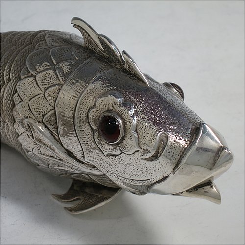 A rare Antique Victorian Silver large articulated fish, with hand engraved and chased body having  articulated scales, a hinged mouth and face with cabochon garnet eyes, with a tail fin, dorsal fin, and sitting on two lower pelvic fins. Made in ca. 1890 in mainland Continental Europe (possibly Spain). The dimension of this fine hand-made antique silver fish model are length 30.5 cms (12 inches), and it weighs approx. 283g (9 troy ounces).