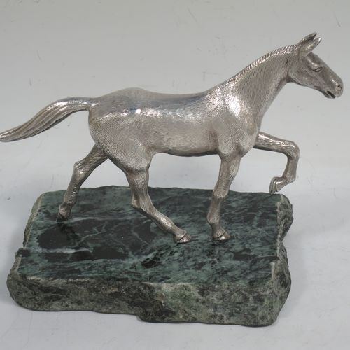 A handsome Sterling Silver cast model of a horse in a cantering pose, and fixed to a green marble base. Made by Albert Edward Jones of Birmingham in 1972. The dimensions of this fine hand-made silver horse are height 11.5 cms (4.5 inches), and length 15 cms (6 inches).   