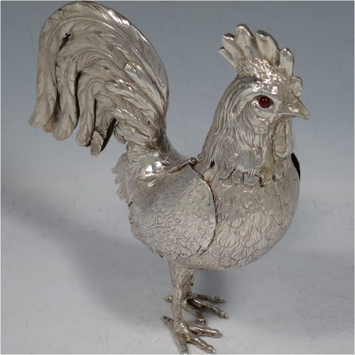 An Antique Edwardian Sterling Silver model of a Rooster or Cockerel bird, having realistically hand-chased feathers, a pull-off head with garnet eyes, with hinged wings, and cast feet. Imported and having hallmarks for Chester in 1903. The dimensions of this fine hand-made antique silver cockerel rooster model are height 14 cms (5.5 inches), length 13 cms (5 inches), width 5.5 cms (2.25 inches), and it weighs approx. 250g (8 troy ounces).   