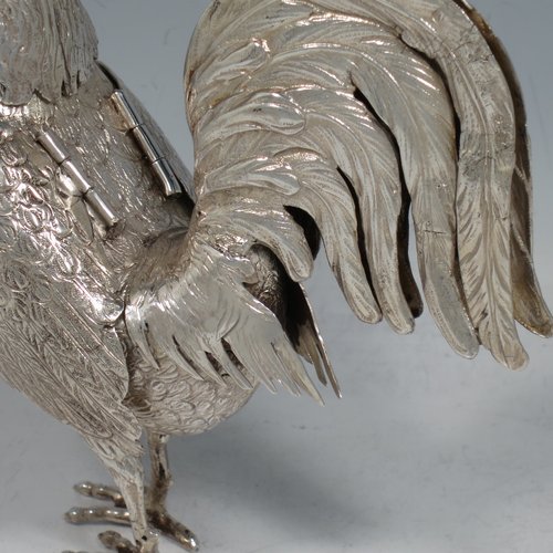 An Antique Edwardian Sterling Silver model of a Rooster or Cockerel bird, having realistically hand-chased feathers, a pull-off head with garnet eyes, with hinged wings, and cast feet. Imported and having hallmarks for Chester in 1903. The dimensions of this fine hand-made antique silver cockerel rooster model are height 14 cms (5.5 inches), length 13 cms (5 inches), width 5.5 cms (2.25 inches), and it weighs approx. 250g (8 troy ounces).   