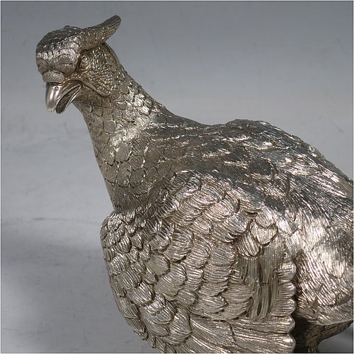 A Sterling Silver large pair of cast pheasants, showing a male and female bird in realistic traditional poses, finely detailed with hand-chased bodies and tail feathers. Made by C. J. Vanders of London in 2000. The dimensions of these fine hand-made sterling silver pheasants are length of male bird 28 cms (11 inches), height 17 cms (6.75 inches), and they weigh a total approx. 1,945g (63 troy ounces).   