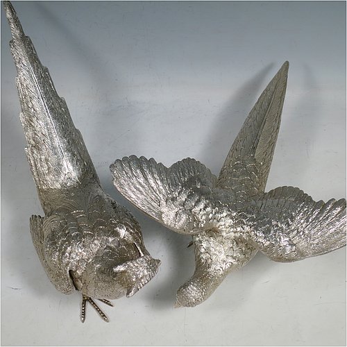 A Sterling Silver large pair of cast pheasants, showing a male and female bird in realistic traditional poses, finely detailed with hand-chased bodies and tail feathers. Made by C. J. Vanders of London in 2000. The dimensions of these fine hand-made sterling silver pheasants are length of male bird 28 cms (11 inches), height 17 cms (6.75 inches), and they weigh a total approx. 1,945g (63 troy ounces).   