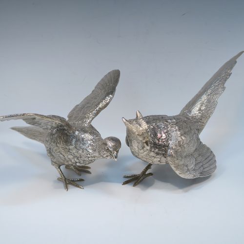 A very handsome Antique Silver-Plated pair of solid cast pheasants, showing a male and female bird in realistic traditional poses, finely detailed with hand-chased bodies and tail feathers. These beautiful silver-plated pheasants were made in ca. 1920. The dimensions of these fine hand-made silver-plated pheasants are length of female bird 28 cms (11 inches), spread across wings 21.5 cms (8.5 inches), and height of male bird to top of head 11 cms (4.3 inches).  