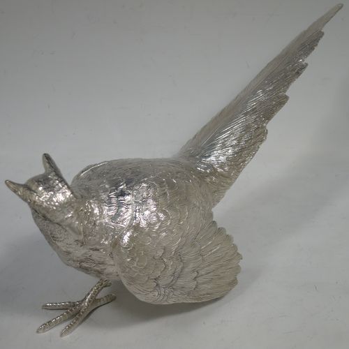 A very handsome Sterling Silver large pair of cast pheasants, showing a male and female bird in realistic traditional poses, finely detailed with hand-chased bodies and tail feathers. Made by C. J. Vanders of London in 2018. The dimensions of these fine hand-made cast sterling silver pheasants are length of male bird 30 cms (11.75 inches), height 14 cms (5.5 inches), and they weigh a total of approx. 2,079g (67 troy ounces).    