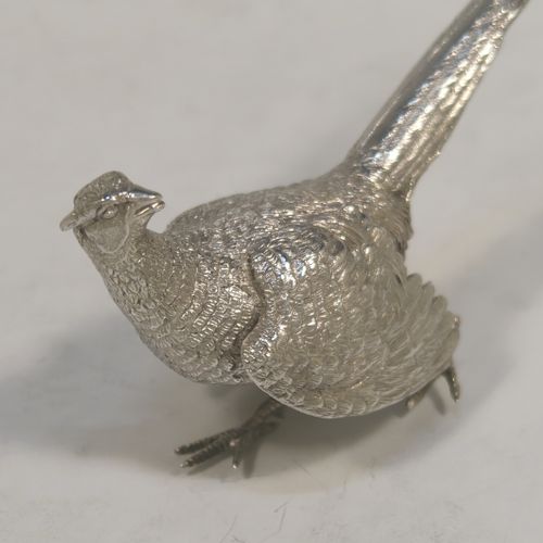 A very handsome Sterling Silver pair of solid cast pheasants, showing a male and female bird in realistic traditional poses, finely detailed with hand-chased bodies and tail feathers. These beautiful silver pheasants were made by C. J. Vander of Sheffield in 1995. The dimensions of these fine hand-made sterling silver pheasants are length of female bird 13.5 cms (5.25 inches), spread across wings 8 cms (6 inches), height of male bird to top of head 6 cms (2.3 inches), and they weigh a total approx. 305g (9.8 troy ounces).  