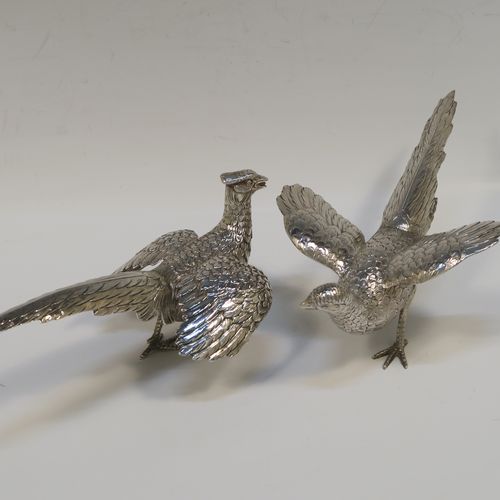 A very handsome Sterling Silver pair of solid cast pheasants, showing a male and female bird in realistic traditional poses, finely detailed with hand-chased bodies and tail feathers. These beautiful silver pheasants were made by I. Freeman of London in 1974. The dimensions of these fine hand-made sterling silver pheasants are length of female bird 19 cms (7.5 inches), spread across wings 12 cms (4.75 inches), height of male bird to top of head 9 cms (3.5 inches), and they weigh a total approx. 320g (10.3 troy ounces).   