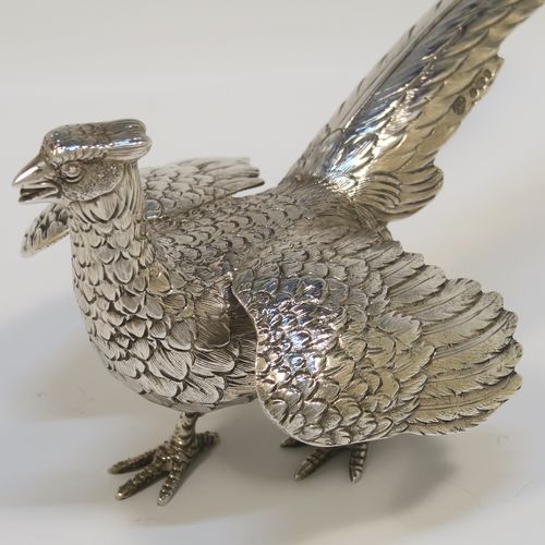 A very handsome Sterling Silver pair of solid cast pheasants, showing a male and female bird in realistic traditional poses, finely detailed with hand-chased bodies and tail feathers. These beautiful silver pheasants were made by I. Freeman of London in 1974. The dimensions of these fine hand-made sterling silver pheasants are length of female bird 19 cms (7.5 inches), spread across wings 12 cms (4.75 inches), height of male bird to top of head 9 cms (3.5 inches), and they weigh a total approx. 320g (10.3 troy ounces).   