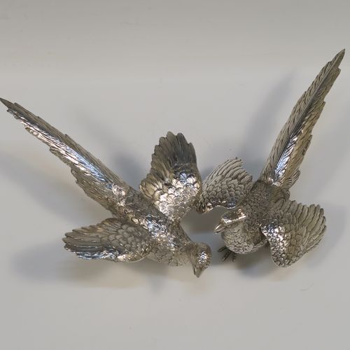 A very handsome Sterling Silver pair of solid cast pheasants, showing a male and female bird in realistic traditional poses, finely detailed with hand-chased bodies and tail feathers. These beautiful silver pheasants were made by I. Freeman of London in 1974. The dimensions of these fine hand-made sterling silver pheasants are length of female bird 19 cms (7.5 inches), spread across wings 12 cms (4.75 inches), height of male bird to top of head 9 cms (3.5 inches), and they weigh a total approx. 320g (10.3 troy ounces).   