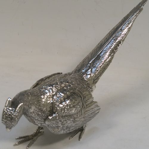 A very handsome Sterling Silver pair of cast pheasants, showing a male and female bird in realistic traditional poses, finely detailed with hand-chased bodies and tail feathers. These beautiful silver pheasants were made by D. J. Silver of London in 1972. The dimensions of these fine hand-made sterling silver pheasants are length of female bird 23 cms (9 inches), spread across wings 15 cms (6 inches), height of male bird to top of head 8 cms (3 inches), and they weigh a total approx. 815g (26.3 troy ounces).   