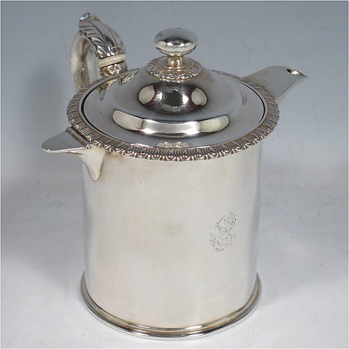 An Antique Victorian Sterling Silver Argyll, having a plain round body with straight sides and an applied gadroon border, a pull-off lid with ball finial, a sparrow-beak spout, a scroll handle with anthemion leaf thumb-piece and bone insulation, a separate side spout with hinged lid for adding hot water to the water jacket, and sitting on a flat base. Made by Thomas Henry & Frederick Francis of London in 1861. The dimensions of this fine hand-made antique silver Argyll are height 12.5 cms (5 inches), diameter 9 cms (3.5 inches), and it weighs approx. 465g (15 troy ounces). Please note that this item is crested.