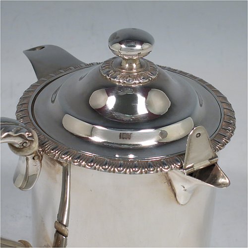 An Antique Victorian Sterling Silver Argyll, having a plain round body with straight sides and an applied gadroon border, a pull-off lid with ball finial, a sparrow-beak spout, a scroll handle with anthemion leaf thumb-piece and bone insulation, a separate side spout with hinged lid for adding hot water to the water jacket, and sitting on a flat base. Made by Thomas Henry & Frederick Francis of London in 1861. The dimensions of this fine hand-made antique silver Argyll are height 12.5 cms (5 inches), diameter 9 cms (3.5 inches), and it weighs approx. 465g (15 troy ounces). Please note that this item is crested.