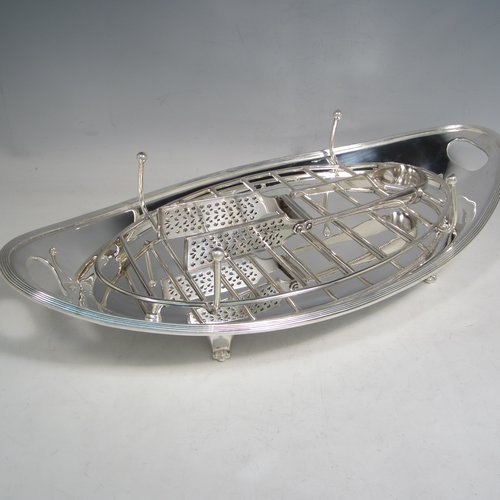 Antique Edwardian silver plated asparagus serving set, having a plain oval body, with an applied reeded border, an original wire-work serving rack, two cut-out side-handles, and sitting on four cast flange feet. Together with a matching pair of tongs made by John Grinsell of Sheffield in ca. 1900. The dimensions of this fine hand-made silver-plated asparagus serving set are length 43 cms (17 inches), and width, 21.5 cms (8.5 inches).   