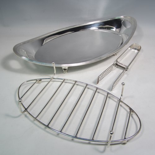 Antique Edwardian silver plated asparagus serving set, having a plain oval body, with an applied reeded border, an original wire-work serving rack, two cut-out side-handles, and sitting on four cast flange feet. Together with a matching pair of tongs made by John Grinsell of Sheffield in ca. 1900. The dimensions of this fine hand-made silver-plated asparagus serving set are length 43 cms (17 inches), and width, 21.5 cms (8.5 inches).   