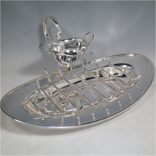 An Antique Edwardian Silver Plated asparagus serving set, having a plain oval body, with an applied rounded border, an original wire-work serving rack, a sauce boat sat in a frame with loop handle, and all sitting on a flat base. Made by Charles Green & Co., of Sheffield in ca. 1900. The dimensions of this fine hand-made silver-plated asparagus serving set are length 34 cms (13.5 inches), and width, 19 cms (7.5 inches).    