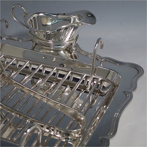 An Antique Edwardian Silver Plated asparagus serving set, having a plain rectangular body, with an applied and shaped reeded border, a wire-work serving rack, a sauce boat sat in a frame with loop handle, a pair of asparagus server tongs, and all sitting on a base with four button feet. All pieces were made by the Atkins Brothers of Sheffield in ca. 1900. The dimensions of this fine hand-made silver-plated asparagus serving set are length 29 cms (11.5 inches), and width, 23 cms (9 inches).    