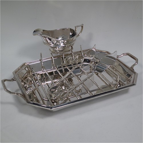 An Art Deco style Silver Plated asparagus serving set, having a plain elongated octagonal body, with an applied reeded border and two cast side-handles, a wire-work serving rack, a sauce boat sat in a frame with loop handle, a pair of asparagus server tongs, and all sitting on a flat base. All pieces are original and were made in England, circa 1930. The dimensions of this fine hand-made silver-plated Art Deco asparagus serving set are length 32.5 cms (12.75 inches), and width, 20 cms (8 inches). 