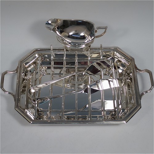 An Art Deco style Silver Plated asparagus serving set, having a plain elongated octagonal body, with an applied reeded border and two cast side-handles, a wire-work serving rack, a sauce boat sat in a frame with loop handle, a pair of asparagus server tongs, and all sitting on a flat base. All pieces are original and were made in England, circa 1930. The dimensions of this fine hand-made silver-plated Art Deco asparagus serving set are length 32.5 cms (12.75 inches), and width, 20 cms (8 inches). 