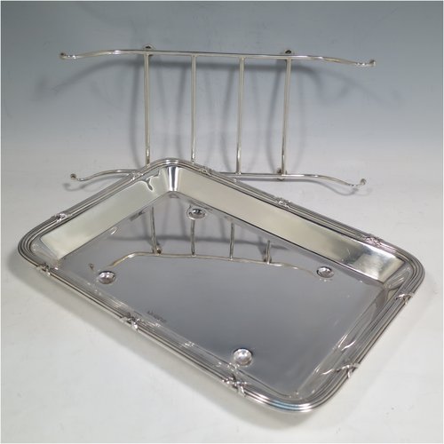 An Antique Edwardian Sterling Silver asparagus serving set, having a plain rectangular body with rounded corners, an applied Ribbon & Reed border, an original wire-work serving rack, and all sitting on a base with four cushion feet. Made by Mappin & Webb of Sheffield in 1909. The dimensions of this fine hand-made antique silver asparagus serving set are length 27 cms (10.5 inches), and width, 19 cms (7.5 inches), and it weighs approx. 727g (23.5 troy ounces).