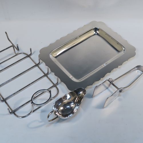 A very elegant Antique Edwardian Silver Plated asparagus serving set, having a plain rectangular body with a Chippendale border, a wire-work serving rack, a sauce boat sat in a frame with loop handle, a pair of asparagus server tongs, and all sitting on a flat base. This handsome silver-plated asparagus serving set was made made by Gladwins Ltd., of Sheffield in ca. 1910. The dimensions of this fine hand-made silver-plated asparagus serving set are length 28 cms (11 inches), and width, 21 cms (8.25 inches).  