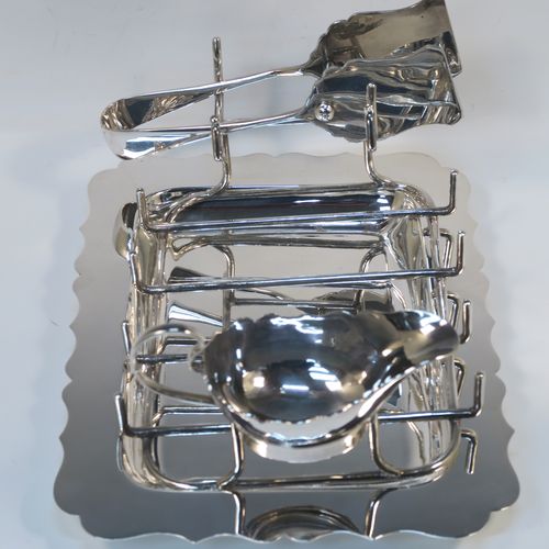 A very elegant Antique Edwardian Silver Plated asparagus serving set, having a plain rectangular body with a Chippendale border, a wire-work serving rack, a sauce boat sat in a frame with loop handle, a pair of asparagus server tongs, and all sitting on a flat base. This handsome silver-plated asparagus serving set was made made by Gladwins Ltd., of Sheffield in ca. 1910. The dimensions of this fine hand-made silver-plated asparagus serving set are length 28 cms (11 inches), and width, 21 cms (8.25 inches).  