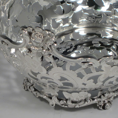 Antique Victorian sterling silver table basket, having an oval hand-pierced and engraved body with floral decoration, with cast floral borders, and sitting on four cast floral feet. Made by D. & J. Wellby of London in 1901. The dimensions of this fine hand-made silver basket are length 18 cms (7 inches), width 16 cms (6.25 inches), height 9 cms (3.5 inches), and it weighs approx. 336g (10.8 troy ounces).