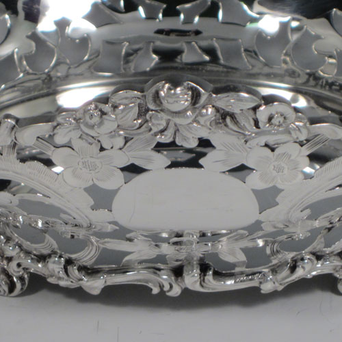 Antique Victorian sterling silver table basket, having an oval hand-pierced and engraved body with floral decoration, with cast floral borders, and sitting on four cast floral feet. Made by D. & J. Wellby of London in 1901. The dimensions of this fine hand-made silver basket are length 18 cms (7 inches), width 16 cms (6.25 inches), height 9 cms (3.5 inches), and it weighs approx. 336g (10.8 troy ounces).