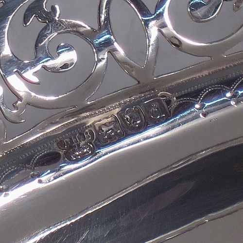 A very pretty Antique Victorian Sterling Silver basket, having an oval body with an applied gadroon border, all hand-pierced with floral and scroll decoration, a hinged swing handle, and all sitting on an oval stepped pedestal foot. Made by J.H. and H. Barraclough of London in 1899. The dimensions of this fine hand-made antique silver basket are height 21 cms (8.25 inches), length 26.5 cms (10.5 inches), width 20 cms (8 inches), and it weighs approx. 548g (17.7 troy ounces).    