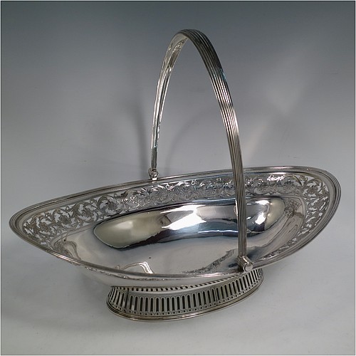 A very pretty Antique Georgian Sterling Silver basket, having an oval body with an applied reeded border, with an upper band of hand-engraved and hand-pierced floral work, a hinged and reeded swing handle, all sitting on a geometrically hand-pierced collet foot. Made by Thomas Harper I of London in 1796. The dimensions of this fine hand-made antique silver basket are height 28 cms (11 inches), length 37 cms (14.5 inches), width 26 cms (10.25 inches), and it weighs approx. 792g (25.5 troy ounces). Please note that this basket is crested.