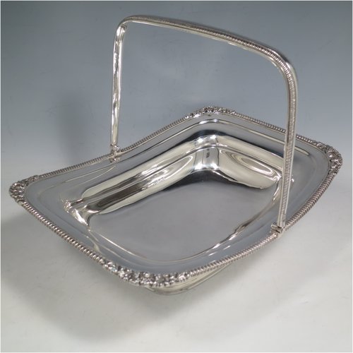 An Antique Edwardian Sterling Silver basket, having a rectangular body, with an applied gadroon and shell border, a hinged and swing handle with gadroon edges, all sitting on a plain pedestal foot. Made by the Barnard Brothers of London in 1903. The dimensions of this fine hand-made silver basket are height 21 cms (8.25 inches), length 27.5 cms (10.75 inches), width 20.5 cms (8 inches), and it weighs approx. 701g (22.6 troy ounces).   