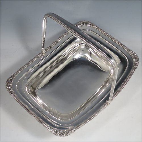 An Antique Edwardian Sterling Silver basket, having a rectangular body, with an applied gadroon and shell border, a hinged and swing handle with gadroon edges, all sitting on a plain pedestal foot. Made by the Barnard Brothers of London in 1903. The dimensions of this fine hand-made silver basket are height 21 cms (8.25 inches), length 27.5 cms (10.75 inches), width 20.5 cms (8 inches), and it weighs approx. 701g (22.6 troy ounces).   