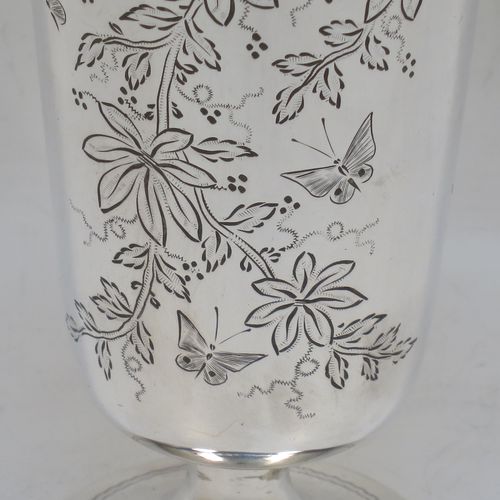 A very pretty Antique Victorian Sterling Silver beaker, having a round straight-sided body with tapering sides, with hand-engraved floral decoration and butterflies, and vacant cartouches either side, and all sitting on a round pedestal foot. Made by Charles Boyton of London in 1885. The dimensions of this fine hand-made antique silver beaker are height 14 cms (5.5 inches), diameter at top 6.5 cms (2.5 inches), and it weighs approx. 171g (5.5 troy ounces).  