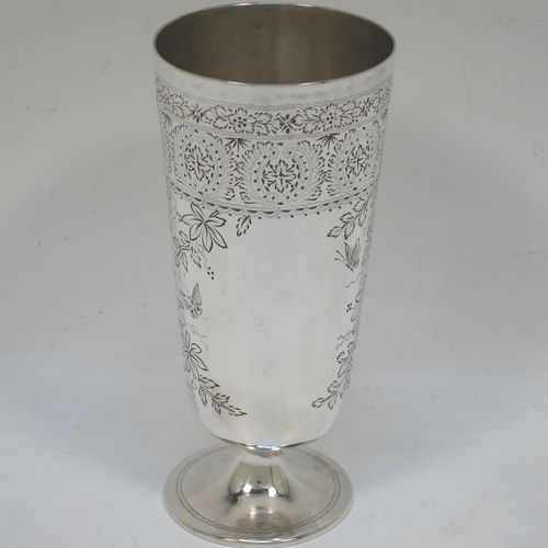 A very pretty Antique Victorian Sterling Silver beaker, having a round straight-sided body with tapering sides, with hand-engraved floral decoration and butterflies, and vacant cartouches either side, and all sitting on a round pedestal foot. Made by Charles Boyton of London in 1885. The dimensions of this fine hand-made antique silver beaker are height 14 cms (5.5 inches), diameter at top 6.5 cms (2.5 inches), and it weighs approx. 171g (5.5 troy ounces).  