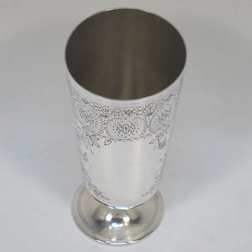 A very pretty Antique Victorian Sterling Silver beaker, having a round straight-sided body with tapering sides, with hand-engraved floral decoration and butterflies, and vacant cartouches either side, and all sitting on a round pedestal foot. Made by Charles Boyton of London in 1885. The dimensions of this fine hand-made antique silver beaker are height 14 cms (5.5 inches), diameter at top 6.5 cms (2.5 inches), and it weighs approx. 171g (5.5 troy ounces).  