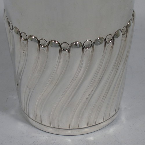 A very handsome Antique Edwardian Sterling Silver beaker, having a round straight-sided body with tapering sides, hand-chased work with half-swirl fluted decoration, with a gold-gilt interior, and all sitting on a flat base. Made by Henry Atkins of Sheffield in 1902. The dimensions of this fine hand-made antique silver beaker are height 10 cms (4 inches), diameter at top 7 cms (2.75 inches), and it weighs approx. 124g (4 troy ounces). 