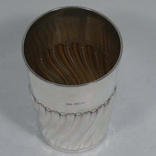 A very handsome Antique Edwardian Sterling Silver beaker, having a round straight-sided body with tapering sides, hand-chased work with half-swirl fluted decoration, with a gold-gilt interior, and all sitting on a flat base. Made by Henry Atkins of Sheffield in 1902. The dimensions of this fine hand-made antique silver beaker are height 10 cms (4 inches), diameter at top 7 cms (2.75 inches), and it weighs approx. 124g (4 troy ounces). 