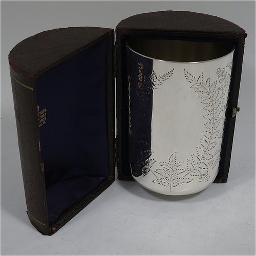 An Antique Victorian Sterling Silver beaker, having a round straight-sided body with tucked under flat base, with hand-engraved fern-work, two vacant oval cartouches on either side, with a gold-gilt interior, and in its original dark blue satin and velvet-lined presentation box. Made by Wakely and Wheeler of London in 1887. The dimensions of this fine hand-made antique silver beaker are height 10 cms (4 inches), diameter at top 7 cms (2.75 inches), and it weighs approx. 129g (4.2 troy ounces). Please note that the box is embossed with initials on the exterior.