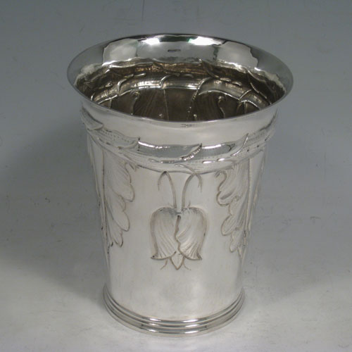 A very unusual and pretty Britannia Standard Silver Art Nouveau style beaker, having a round body with tapering sides, hand-chased floral decoration with tulips, and sitting on a collet foot. Made by S. J. Phillips of London in 1935, with extra Jubilee mark. The dimensions of this fine hand-made silver beaker are height 12 cms (4.75 inches), diameter at top 10 cms (4 inches), and it weighs approx. 244g (7.9 troy ounces).  