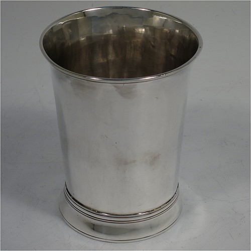 A very handsome Antique Georgian Sterling Silver beaker, having a very plain round body with tapering sides, reeded top and bottom borders, and sitting on a collet foot. Made by Thomas Wallis I  of London in 1770. The dimensions of this fine hand-made antique silver beaker are height 9 cms (3.5 inches), diameter at top 7 cms (2.75 inches), and it weighs approx. 123g (4 troy ounces).    