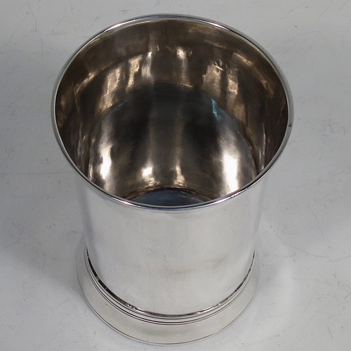 A very handsome Antique Georgian Sterling Silver beaker, having a very plain round body with tapering sides, reeded top and bottom borders, and sitting on a collet foot. Made by Thomas Wallis I  of London in 1770. The dimensions of this fine hand-made antique silver beaker are height 9 cms (3.5 inches), diameter at top 7 cms (2.75 inches), and it weighs approx. 123g (4 troy ounces).    