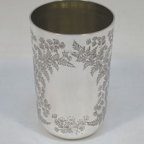 A very pretty Antique Victorian Sterling Silver beaker, having a round straight-sided body with tapering sides and a tucked under base, with hand-engraved ferns and gingko leaves surrounding two vacant cartouches either side, a gold-gilt interior and all sitting on a flat base. Made by F. C. W. Ltd., of London in 1889. The dimensions of this fine hand-made antique silver beaker are height 9 cms (3.5 inches), diameter at top 6 cms (2.25 inches), and it weighs approx. 75g (2.4 troy ounces).   