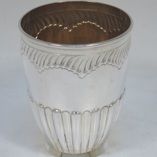 A very pretty Antique Victorian Sterling Silver pair of beaker cups, having round bodies with tapering sides and hand-chased fluted decoration, god-gilt interiors, and sitting on a collet feet. Made by H. J. Lias and J. Wakely of London in 1882. The dimensions of this fine pair of hand-made antique silver beakers are height 10.5 cms (4.25 inches), diameter at top 8 cms (3.25 inches), and they weigh a total of approx. 282g (9 troy ounces).  