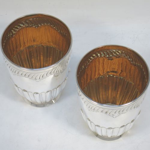 A very pretty Antique Victorian Sterling Silver pair of beaker cups, having round bodies with tapering sides and hand-chased fluted decoration, god-gilt interiors, and sitting on a collet feet. Made by H. J. Lias and J. Wakely of London in 1882. The dimensions of this fine pair of hand-made antique silver beakers are height 10.5 cms (4.25 inches), diameter at top 8 cms (3.25 inches), and they weigh a total of approx. 282g (9 troy ounces).  