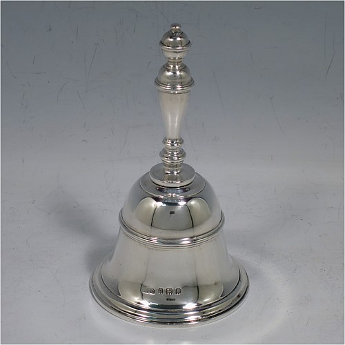 A Sterling Silver Georgian style table bell having a plain round body with applied reeded borders, a cast baluster handle, and an original silver clapper. Made by Carrington and Co., of London in 1929. The dimensions of this fine hand-made silver table bell are height 10.5 cms (4.25 inches), diameter at base 6 cms (2.3 inches), and it weighs approx. 165g (5.3 troy ounces).   